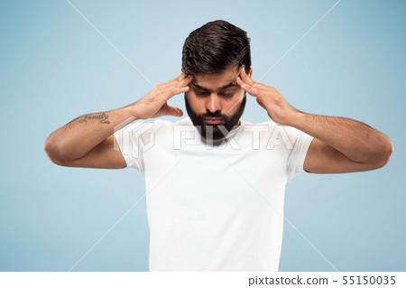Half-length close up portrait of young man on blue background. 55150035