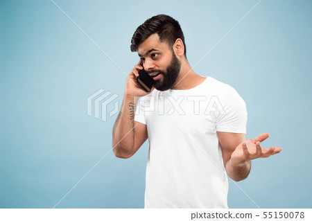 Half-length close up portrait of young man on blue background. 55150078