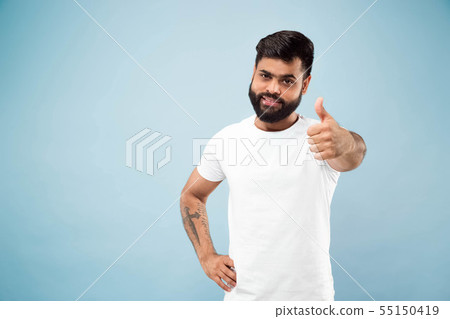 Half-length close up portrait of young man on blue background. 55150419