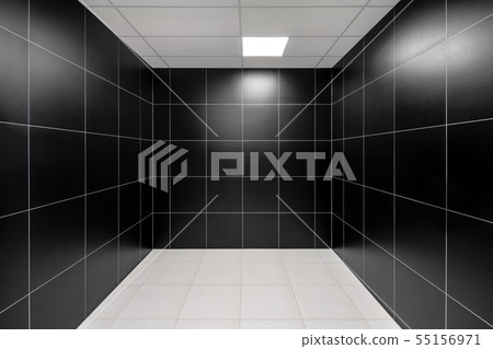 Room in with tiled dark walls and light floor 55156971