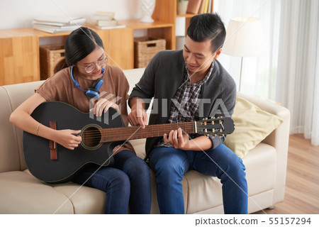 Couple learning to play guitar 55157294
