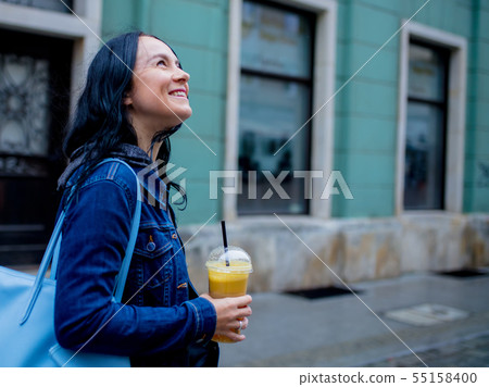 Woman in denim jacket with orange juice Woman in denim jacket with orange juice 55158400