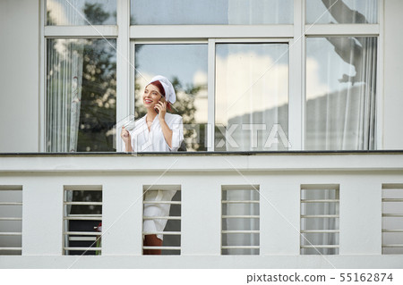 Pretty woman on hotel balcony Pretty woman on hotel balcony 55162874