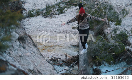 A young woman crossing the river on the log A young woman crossing the river on the log 55165623