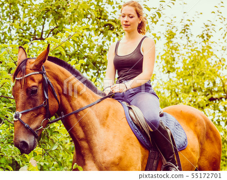 Young woman ridding on a horse 55172701