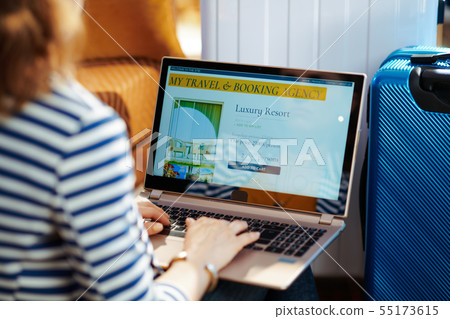 stylish traveller woman booking hotel on laptop stylish traveller woman booking hotel on laptop 55173615