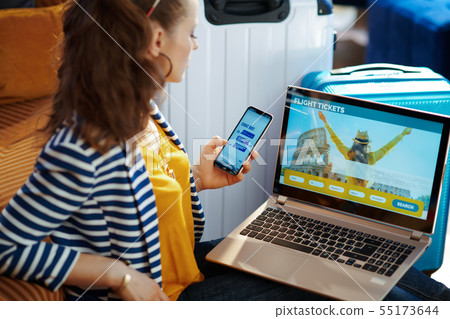 trendy woman booking tickets laptop and using customer service 55173644