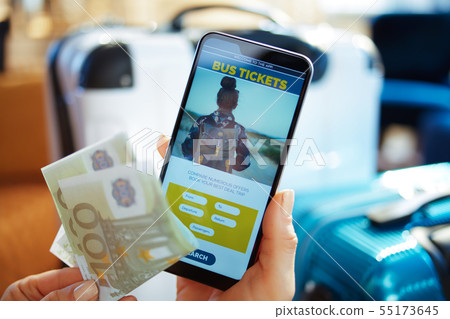 Closeup on female hand with phone booking tickets using app 55173645