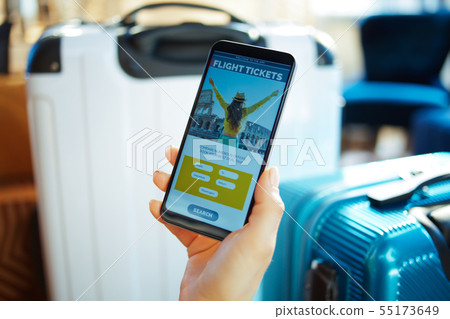 Closeup on female hand with smartphone booking tickets using app 55173649