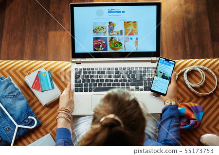 housewife browsing social media on laptop and smartphone 55173753