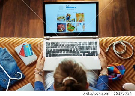 trendy housewife posting on social media on laptop trendy housewife posting on social media on laptop 55173754