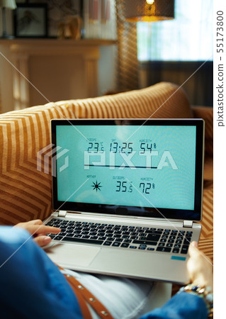 young woman using smart home weather station young woman using smart home weather station 55173800