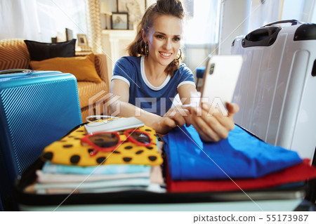 woman at modern home in sunny summer day booking plane ticket 55173987