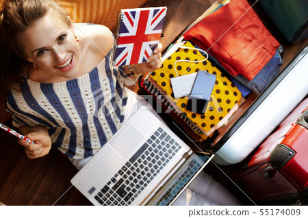 woman with Great Britain flag notebook buying airplane ticket woman with Great Britain flag notebook buying airplane ticket 55174009