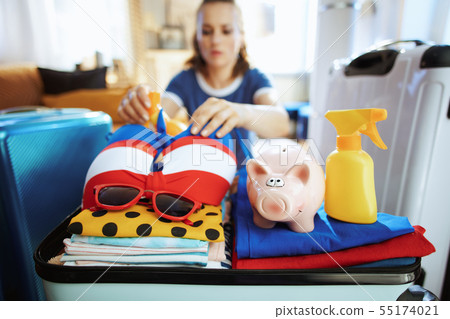 on tourist woman with piggy bank calculates summer budget on tourist woman with piggy bank calculates summer budget 55174021