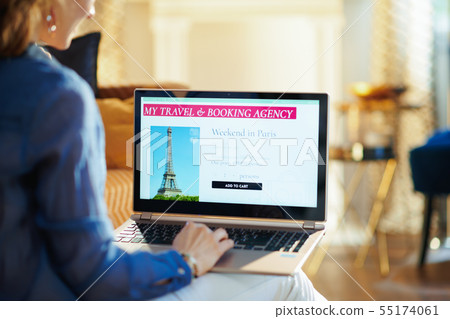 young woman with online travel site on laptop 55174061