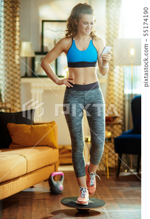 woman updating fitness blog via smartphone while training 55174190