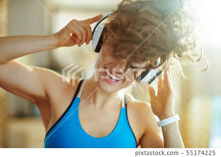 woman listening to music with headphones in modern house woman listening to music with headphones in modern house 55174225