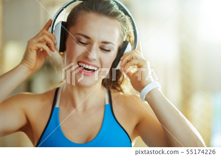 happy woman listening to music with headphones in modern house happy woman listening to music with headphones in modern house 55174226