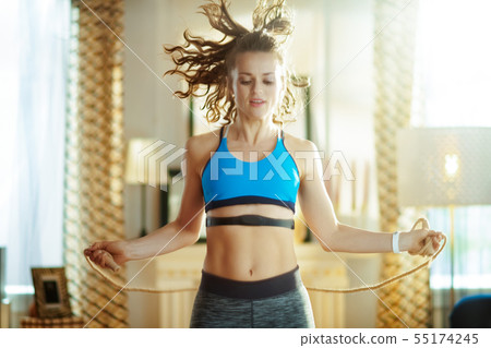 active woman exercise using jump rope with heart rate monitor active woman exercise using jump rope with heart rate monitor 55174245