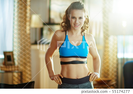 fit sports woman at modern home wearing heart rate monitor 55174277