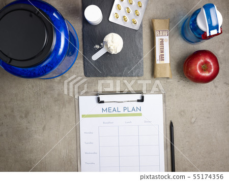 Closeup on big blue protein jar and clipboard with meal plan 55174356