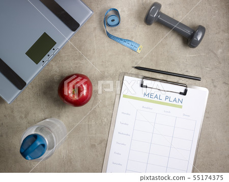 weight scales, apple, tape measure and clipboard with meal plan 55174375