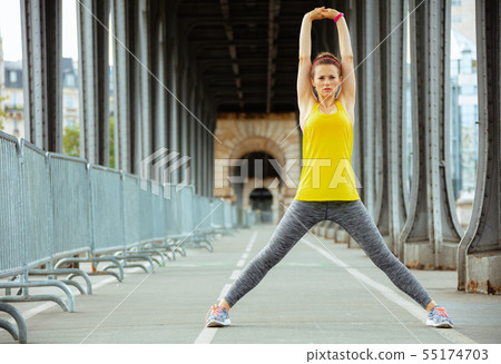 sports woman on Pont de Bir-Hakeim bridge in Paris stretching sports woman on Pont de Bir-Hakeim bridge in Paris stretching 55174703