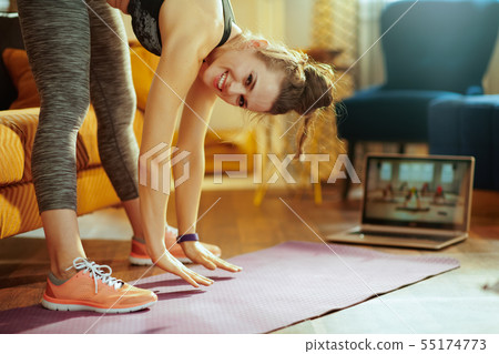woman using laptop to watch fitness streaming on internet 55174773