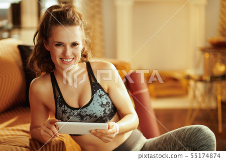 woman using online fitness training program in tablet PC 55174874