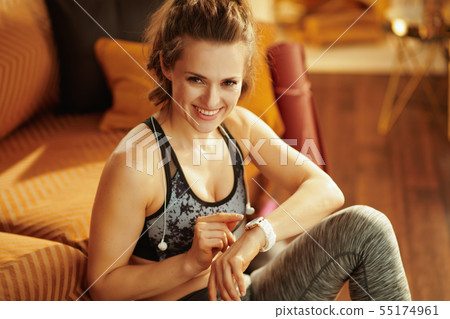 woman using smart watch to track heart rate in fitness app woman using smart watch to track heart rate in fitness app 55174961