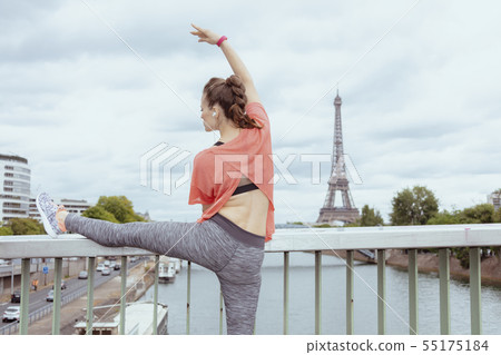 woman jogger stretching against Eiffel tower in Paris, France woman jogger stretching against Eiffel tower in Paris, France 55175184