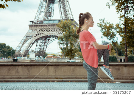 sports woman stretching against Eiffel tower in Paris, France sports woman stretching against Eiffel tower in Paris, France 55175207