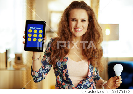 housewife showing tablet PC with smart home application and smar housewife showing tablet PC with smart home application and smar 55175350