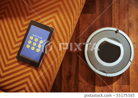 Closeup on tablet PC and robot vacuum on the floor Closeup on tablet PC and robot vacuum on the floor 55175385