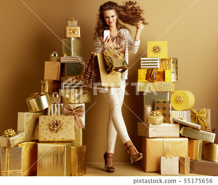 shopper woman with smartphone and shopping bags fingers snapping 55175656