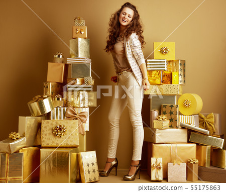 happy fashion-monger among 2 piles of golden gifts dancing 55175863