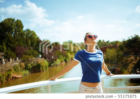 relaxed fit woman on river boat enjoying river cruising relaxed fit woman on river boat enjoying river cruising 55175875