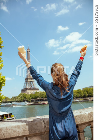 solo tourist woman with cup of coffee and croissant rejoicing solo tourist woman with cup of coffee and croissant rejoicing 55175918