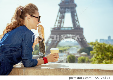 traveller woman with coffee cup eating baguette having excursion 55176174