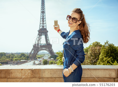 smiling elegant tourist woman taking photo with cellphone smiling elegant tourist woman taking photo with cellphone 55176203