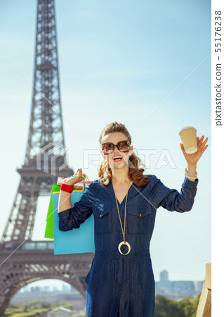 smiling elegant tourist woman with shopping bags and coffee cup smiling elegant tourist woman with shopping bags and coffee cup 55176238