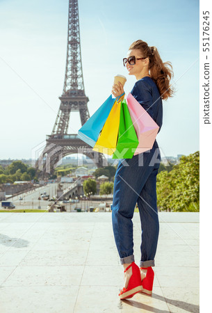 happy trendy traveller woman with shopping bags and coffee cup happy trendy traveller woman with shopping bags and coffee cup 55176245