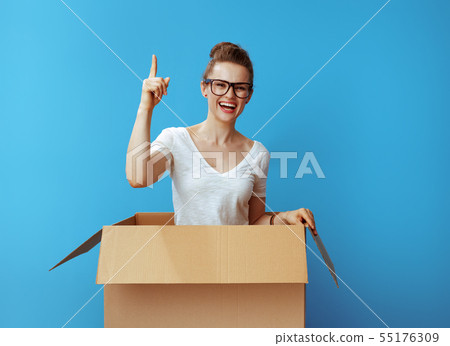 happy young woman in cardboard box got idea on blue 55176309