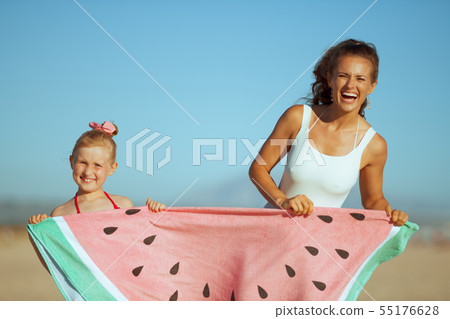 smiling mother and daughter showing funny watermelon towel smiling mother and daughter showing funny watermelon towel 55176628
