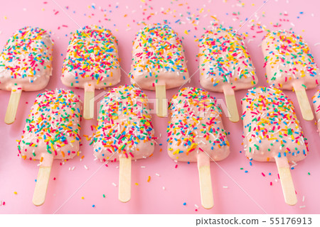 popsicles with sprinkles and icing over pink popsicles with sprinkles and icing over pink 55176913
