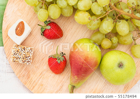 Summer picnic in the meadow on the green grass. Fruit basket, juice and bottled wine, watermelon 55178494