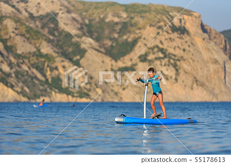 Happy active kid on a Hobie Stand Up Paddle board Happy active kid on a Hobie Stand Up Paddle board 55178613