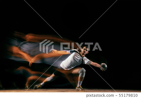 Young handball player against dark studio background in mixed light 55179810