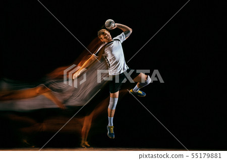 Young handball player against dark studio background in mixed light 55179881